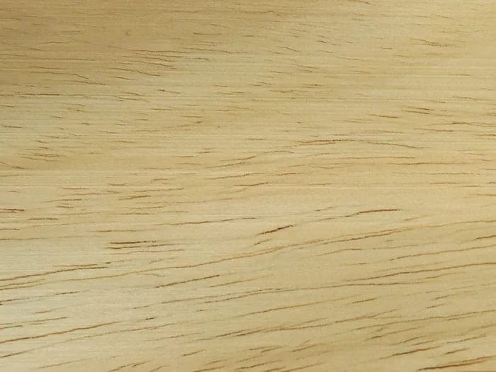 Ayous lumber surface: pale cream wood with fine grain, close-up.