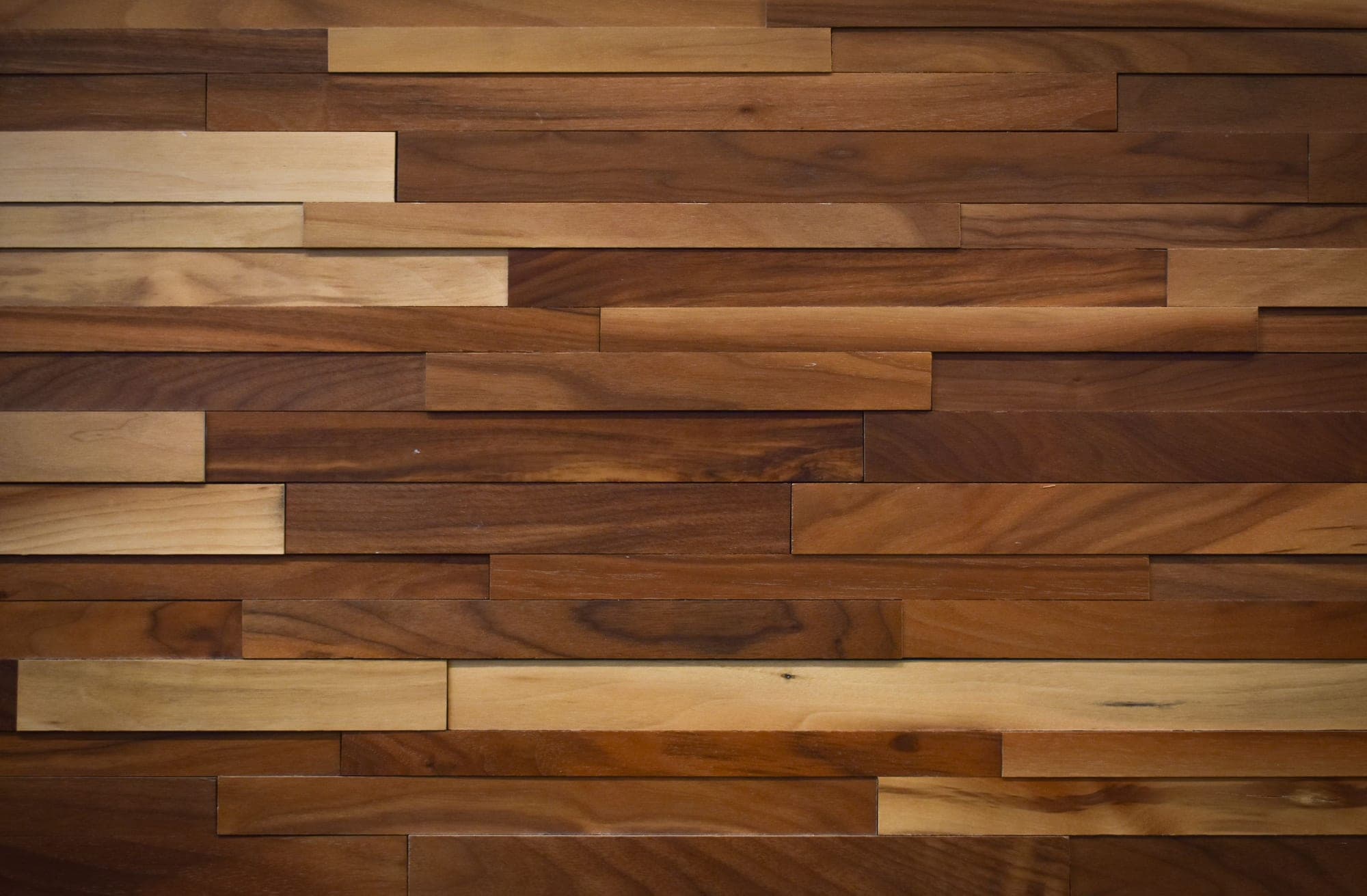 Planed walnut boards: dark brown heartwood and lighter sapwood, close-up.