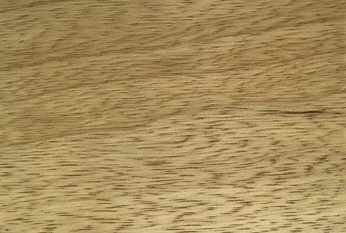Fraké (limba) lumber surface: pale yellowish-brown wood, close-up.