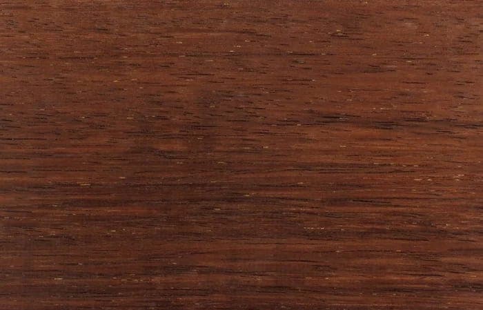 Merbau lumber surface: dark red-brown wood, close-up.